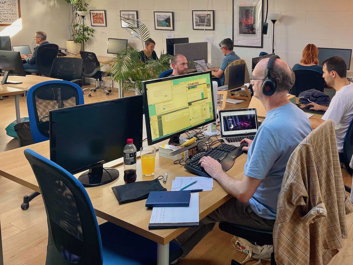 Members working at big desks with monitors at The Skiff